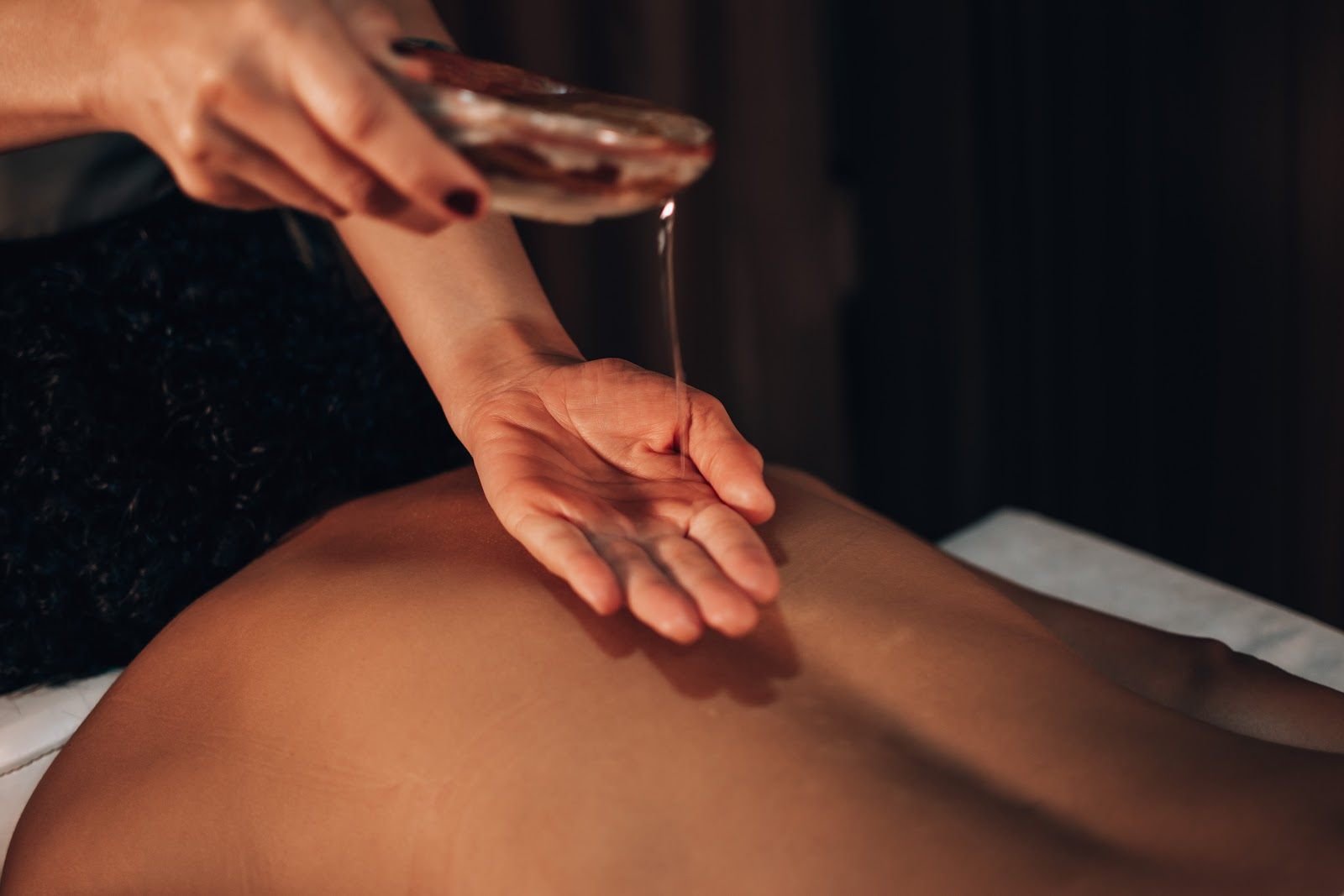 Óleo de massagem sendo aplicado nas costas